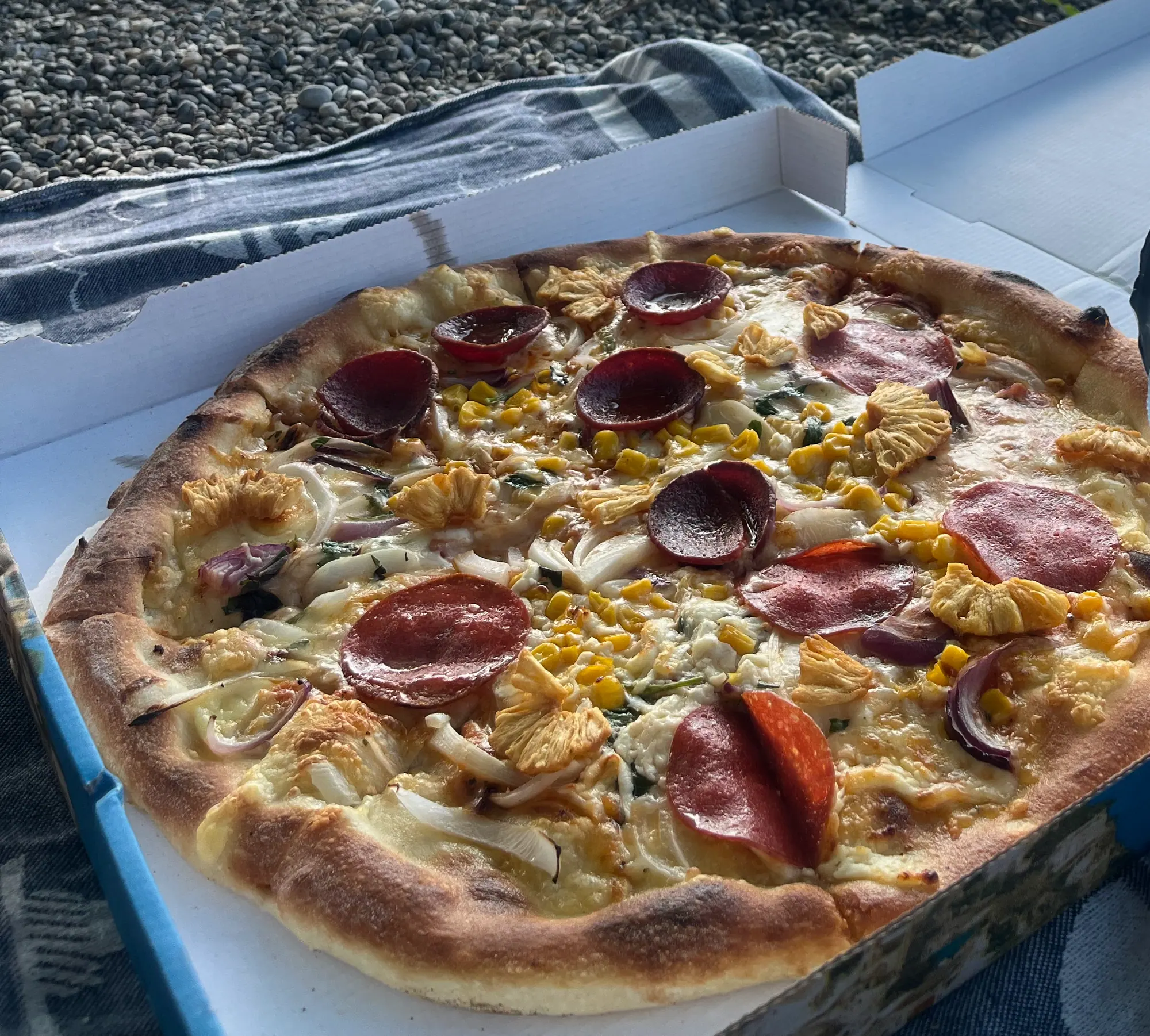 Nahaufnahme einer Pizza mit Salami, Mais und Crispy Ananas